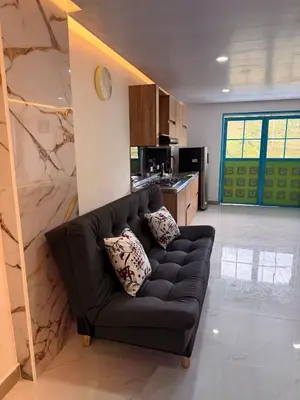 a living room with a black couch in a kitchen at Apartamento céntrico, Guatape, cerca al malecon in Guatapé