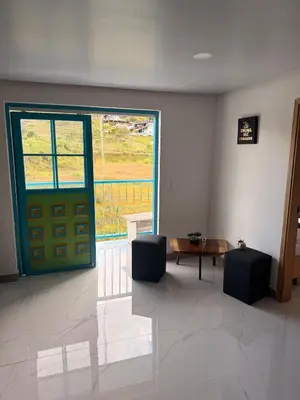 a room with a green door and a table and a window at Apartamento céntrico, Guatape, cerca al malecon in Guatapé
