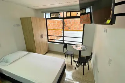a small room with a bed and a table with chairs at Edificio Casa Anita in Medellín