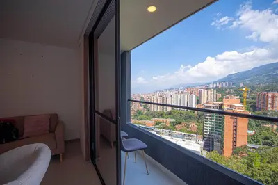 a room with a large window with a view of a city at Modern apartment - Pool, Gym, and Coworking Space in Envigado