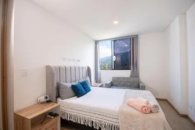 a small bedroom with a bed and a window at Modern apartment - Pool, Gym, and Coworking Space in Envigado