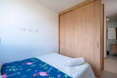 a bedroom with a bed and a wooden door at Modern apartment - Pool, Gym, and Coworking Space in Envigado