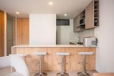 a kitchen with a counter and stools in a room at Modern apartment - Pool, Gym, and Coworking Space in Envigado
