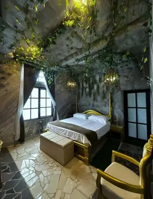 a bedroom with a bed in a stone room with lights at templo de piedra refugio espiritual in Guatapé