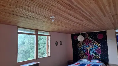 a bedroom with a wooden ceiling and a window at La Rana Azul - Hospedaje rural in Manizales
