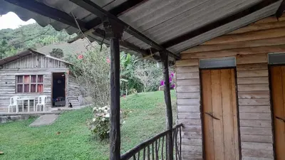 a wooden cabin with a porch and a door at La Rana Azul - Hospedaje rural in Manizales