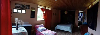 a small room with a couch and a table and window at La Rana Azul - Hospedaje rural in Manizales