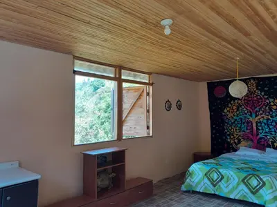 a bedroom with a bed and a window at La Rana Azul - Hospedaje rural in Manizales