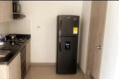 a black refrigerator in the corner of a kitchen at Apartamento central in Sabaneta