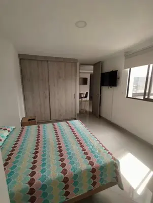 a bedroom with a bed with a colorful quilt on it at Apartamento central in Sabaneta