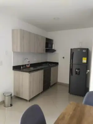 a kitchen with a black refrigerator and a table at Apartamento central in Sabaneta