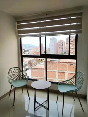 two chairs and a table in front of a window at Apartamento central in Sabaneta