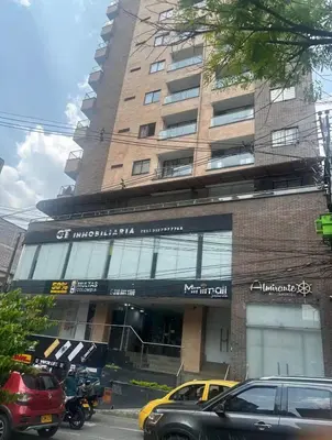a large building with cars parked in front of it at Apartamento central in Sabaneta