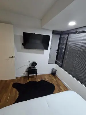 a bedroom with a bed and a flat screen tv on the wall at Modern Apt in Poblado with Private Terrace & Gym in Medellín