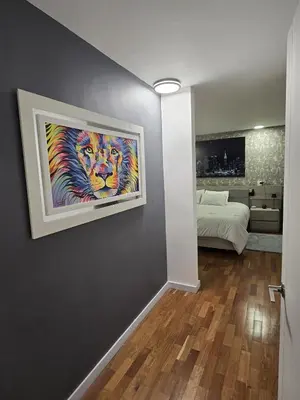 a bedroom with a painting of a lion on the wall at Modern Apt in Poblado with Private Terrace & Gym in Medellín