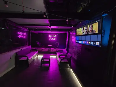 a room with purple lighting and chairs and a tv at Modern Apt in Poblado with Private Terrace & Gym in Medellín