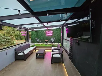 a rooftop patio with chairs and tables and a bar at Modern Apt in Poblado with Private Terrace & Gym in Medellín