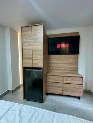 a room with a television and a wooden dresser at Garden Studio Laureles in Medellín