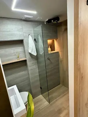a bathroom with a glass shower and a toilet at Garden Studio Laureles in Medellín