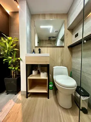 a bathroom with a toilet and a sink and a mirror at Garden Studio Laureles in Medellín