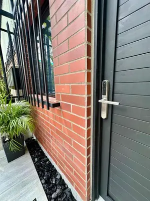 a door to a house with a plant next to it at Garden Studio Laureles in Medellín