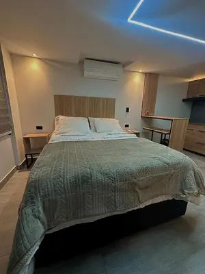 a bedroom with a large bed with a green comforter at Garden Studio Laureles in Medellín