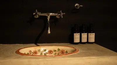 a sink with a faucet and three bottles of wine at Casa Tuti Laureles in Estación El Salto