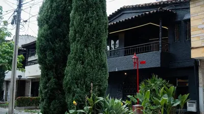 a tall green tree next to a building at Casa Tuti Laureles in Estación El Salto