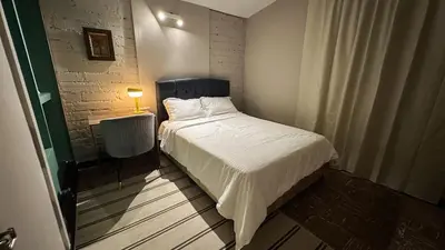 a bedroom with a bed and a table with a lamp at Casa Tuti Laureles in Estación El Salto