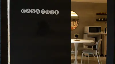 a room with a table with chairs and a black wall at Casa Tuti Laureles in Estación El Salto