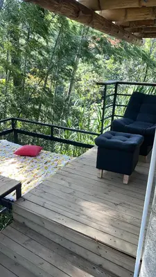 a wooden deck with two chairs and a table at Cabaña vip familiar vista verde in Cocorná