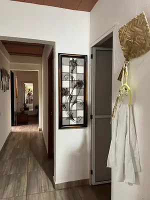 a hallway with a door with a clock on the wall at Casa compartida - Las 5 Quintas in San Rafael