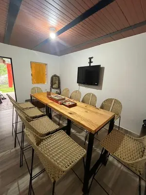 a wooden table with chairs and a tv on a wall at Casa compartida - Las 5 Quintas in San Rafael