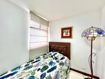a bedroom with a bed and a window and a lamp at medellín palmas sandiego 2 in Medellín