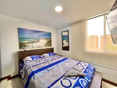 a bedroom with a bed and a view of the beach at medellín palmas sandiego 2 in Medellín