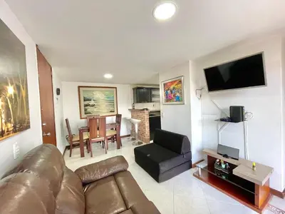 a living room with a leather couch and a television at medellín palmas sandiego 2 in Medellín