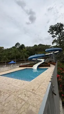 a swimming pool with two blue umbrellas around it at Apto Citadela Di Sole in Santa Fe de Antioquia