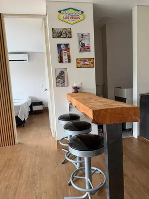 a kitchen with a counter and stools in a room at Apto Citadela Di Sole in Santa Fe de Antioquia
