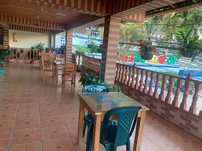 a restaurant with tables and chairs on a patio at Casa Hotel La Cascada