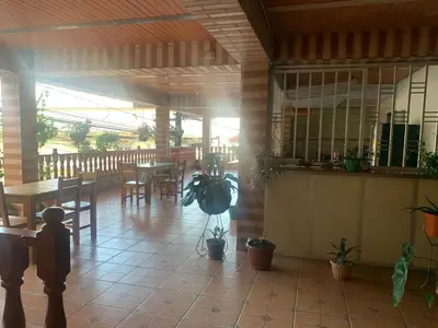 a patio with a table and chairs and a table and a porch at Casa Hotel La Cascada