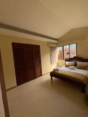 a bedroom with a bed and a large window at Penthouse Rio Claro 1002 in Medellín