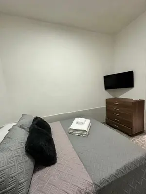 a bedroom with a bed with a dresser and a flat screen tv at Casa espaciosa cerca al estadio in Medellín