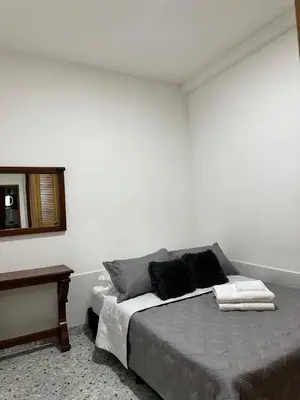 a bedroom with a bed and a mirror and a table at Casa espaciosa cerca al estadio in Medellín
