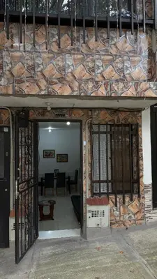 an entrance to a building with a stone wall at Acogedora casa ideal para familias y grupos cerca al estadio barrio Laureles la América in Medellín
