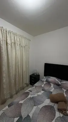 a bedroom with a bed and a window with curtains at Acogedora casa ideal para familias y grupos cerca al estadio barrio Laureles la América in Medellín