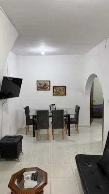 a living room with a table and chairs at Acogedora casa ideal para familias y grupos cerca al estadio barrio Laureles la América in Medellín
