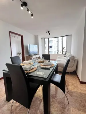 a dining room with a black table and chairs at Cozy apartment with panoramic views in Manizales