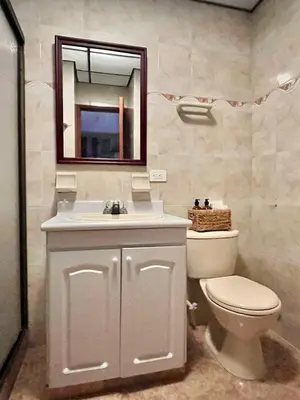 a bathroom with a toilet and a sink and a mirror at Cozy apartment with panoramic views in Manizales