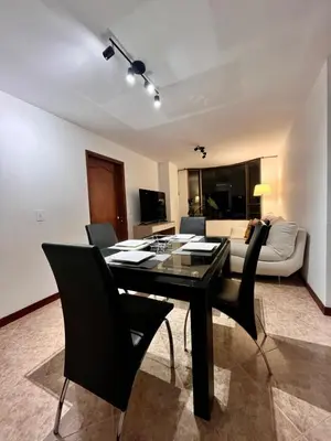 a living room with a table and chairs and a couch at Cozy apartment with panoramic views in Manizales