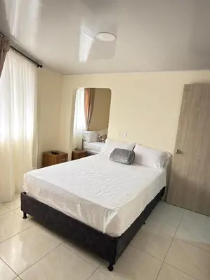 a bedroom with a large bed in a room at Hotel Plaza de Toros in Manizales
